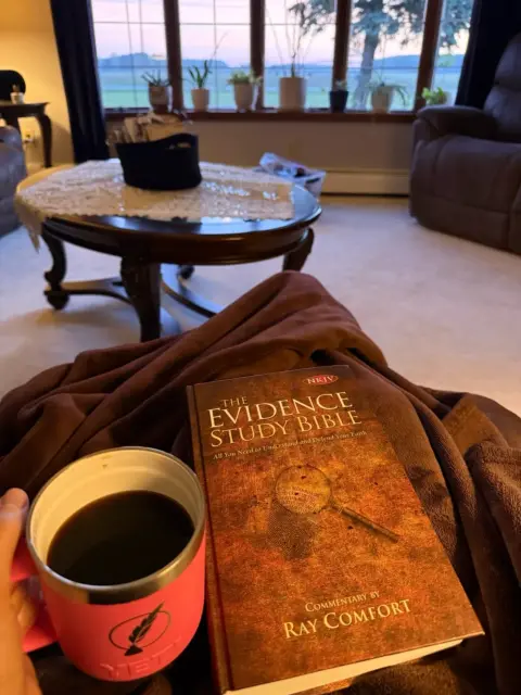 Cup of coffee beside a study Bible, doing devotions in the early morning.